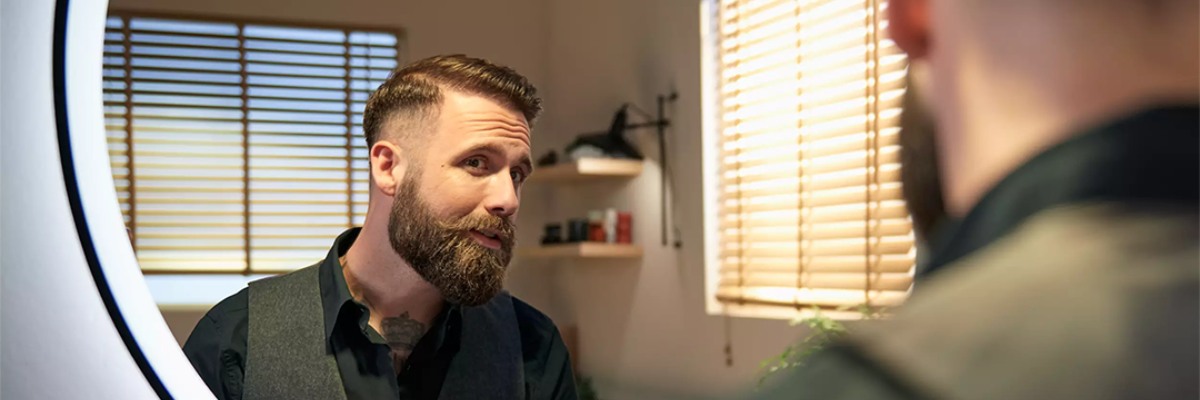 Philips skuveklis un vīrietis kurš skatās spogulī