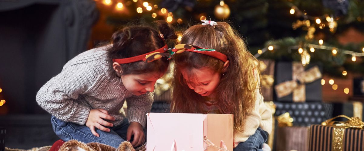 Bērni pēta iepakotu Ziemassvētku dāvanu bērniem