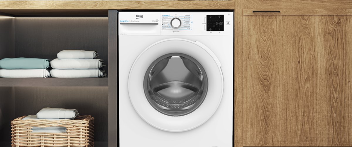 Beko priekšpuses ielādes veļas mašīna starp virtuves mēbelēm – kompakts un vietu taupošs risinājums