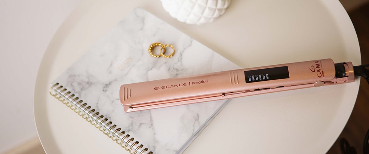 Matu taisnotājs uz galda ar piezīmju grāmatiņu un aksesuāriem, piemērots matu taisnošanai un veidošanai