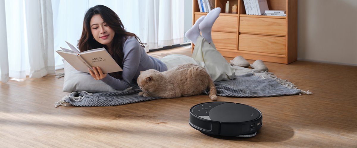 robots putekļu sūcējs tīra grīdu blakus sievietei un mājdzīvniekam